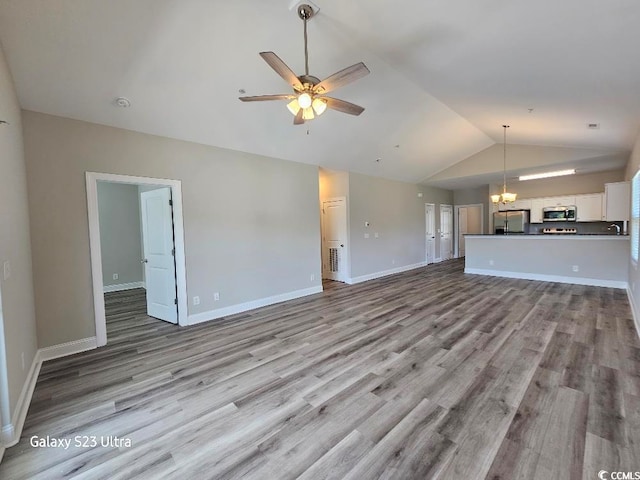 340 Kiskadee Loop, Conway, SC 29526 - unfurnished living room featuring lofted ceiling, wood finished floors, ceiling fan, baseboards, and a chandelier
