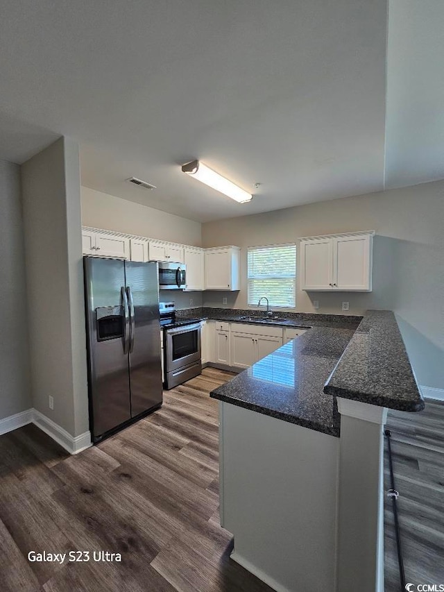340 Kiskadee Loop, Conway, SC 29526 - kitchen featuring stainless steel appliances, a sink, a peninsula, white cabinetry, and dark wood finished floors