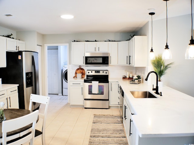 230 Vermillion Dr, Little River, SC 29566 - kitchen with appliances with stainless steel finishes, a sink, a peninsula, washer / clothes dryer, and decorative backsplash