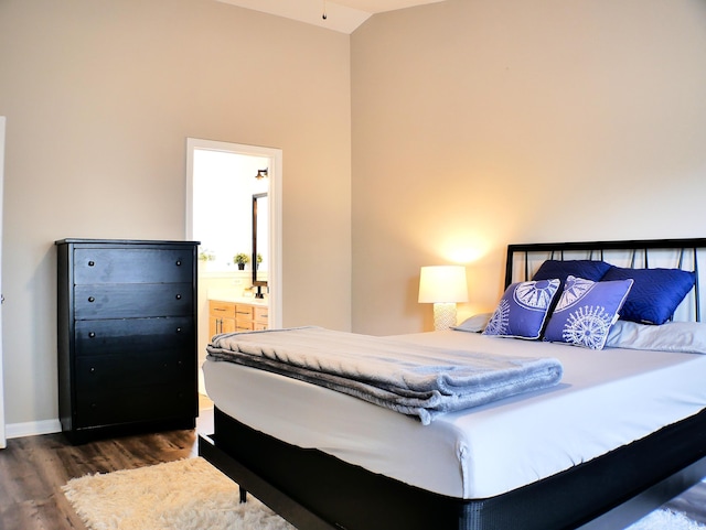 230 Vermillion Dr, Little River, SC 29566 - bedroom with dark wood finished floors, high vaulted ceiling, connected bathroom, and baseboards
