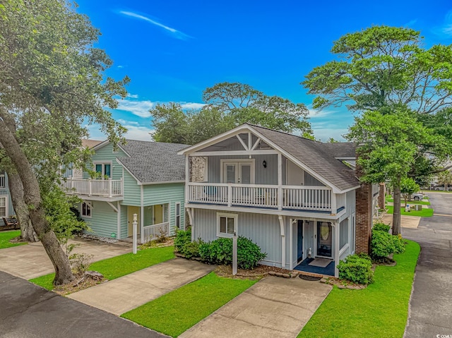 4309 Beverly Ct, North Myrtle Beach, SC 29582 - view of front of home featuring roof with shingles, french doors, a balcony, and a front yard