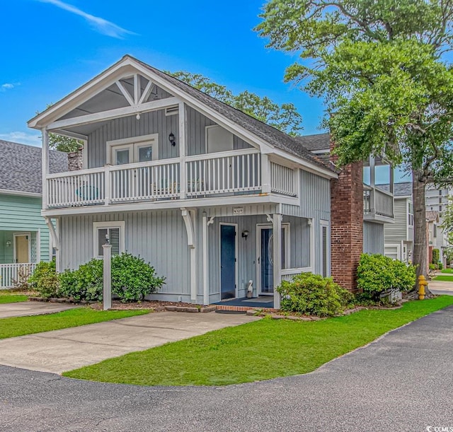 4309 Beverly Ct, North Myrtle Beach, SC 29582 - view of front facade featuring a balcony, roof with shingles, a front yard, and board and batten siding