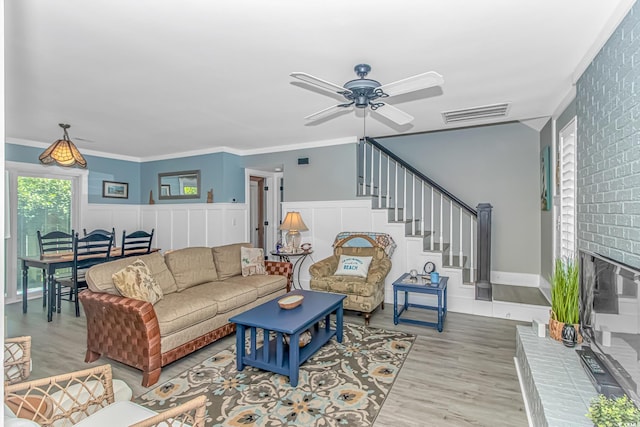 4309 Beverly Ct, North Myrtle Beach, SC 29582 - living area with wood finished floors, a ceiling fan, stairs, a fireplace, and crown molding
