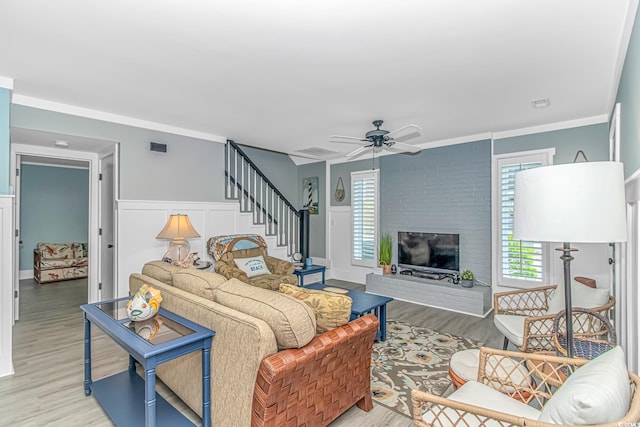 4309 Beverly Ct, North Myrtle Beach, SC 29582 - living room with plenty of natural light, light wood finished floors, stairs, a wainscoted wall, and a brick fireplace