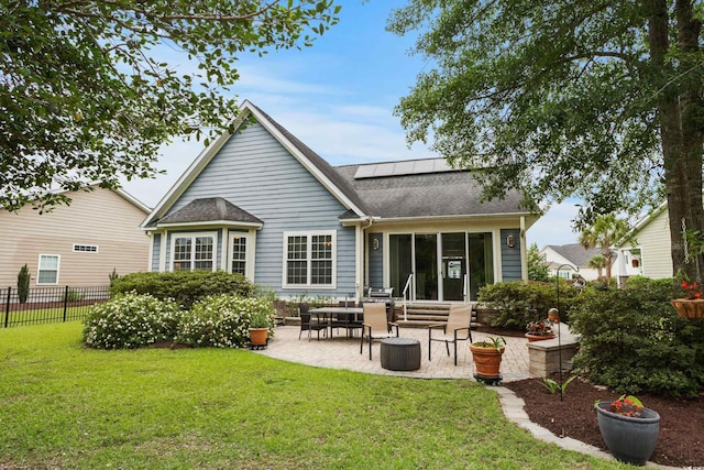 341 Bahama Dr, Murrells Inlet, SC 29576 - back of property featuring roof mounted solar panels, a patio area, and roof with shingles