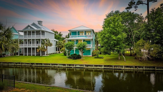 17 Trigger Fish Ln, Murrells Inlet, SC 29576 - rear view of house with a balcony, a water view, a lawn, and a sunroom