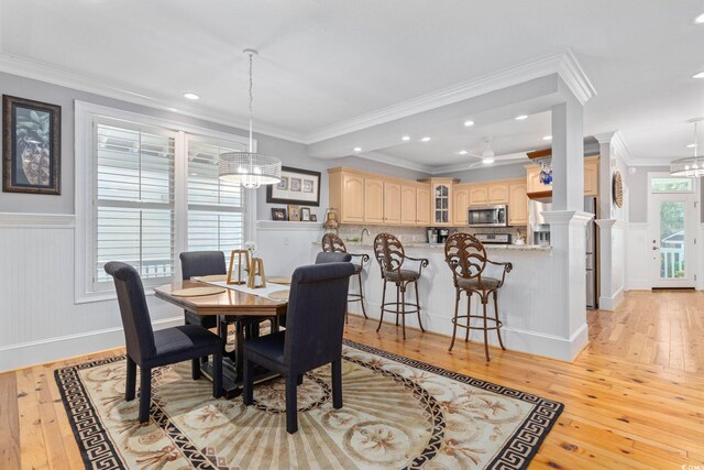 17 Trigger Fish Ln, Murrells Inlet, SC 29576 - dining space with light wood-style flooring, crown molding, a wainscoted wall, recessed lighting, and ornate columns