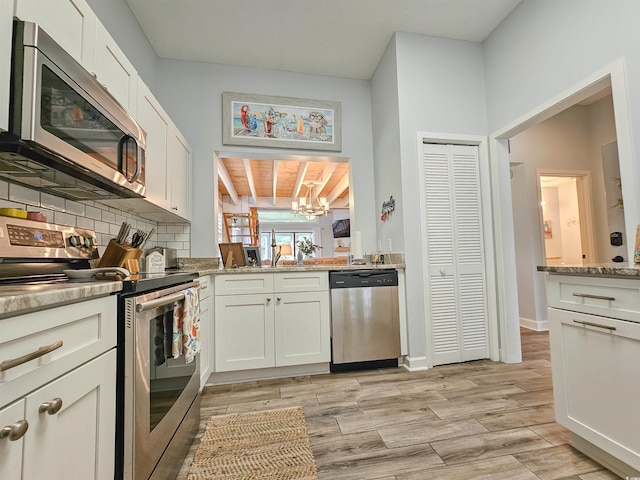 323 Wendover Ct Unit 10-A, Myrtle Beach, SC 29572 - kitchen with stainless steel appliances, a chandelier, backsplash, light wood-style flooring, and white cabinetry
