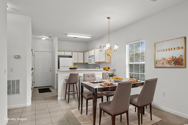 1302 River Oak Dr Unit 4B, Myrtle Beach, SC 29579 - dining space with a chandelier, light tile patterned floors, and baseboards