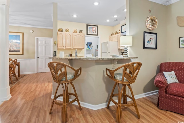 405 Pipers Ln Unit 405, Myrtle Beach, SC 29575 - kitchen featuring freestanding refrigerator, a breakfast bar, light wood-type flooring, light brown cabinetry, and crown molding