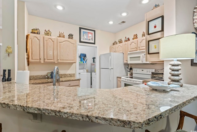 405 Pipers Ln Unit 405, Myrtle Beach, SC 29575 - kitchen with white appliances, light brown cabinets, a peninsula, light stone countertops, and recessed lighting