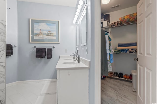 405 Pipers Ln Unit 405, Myrtle Beach, SC 29575 - full bathroom featuring double vanity, a walk in closet, marble finish flooring, and baseboards