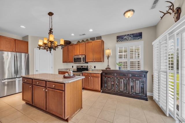 773 Wintercreeper Dr, Longs, SC 29568 - kitchen with appliances with stainless steel finishes, a chandelier, brown cabinetry, light stone counters, and light tile patterned floors
