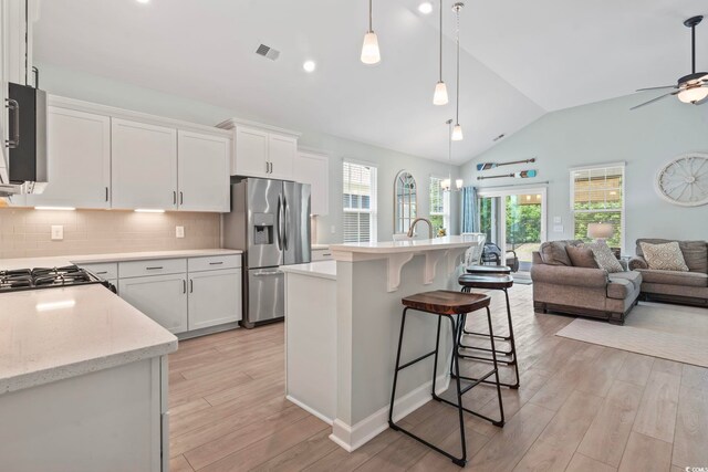 1178 Pyxie Moss Dr, Little River, SC 29566 - kitchen with stainless steel refrigerator with ice dispenser, open floor plan, light wood-type flooring, ceiling fan, and tasteful backsplash