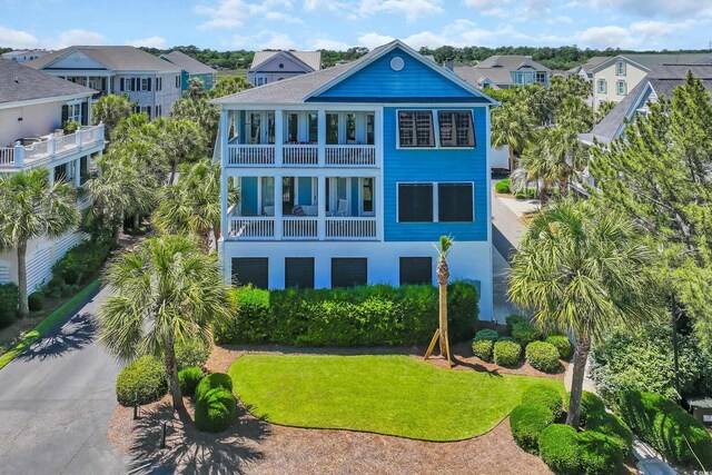 573 S Dunes Dr, Pawleys Island, SC 29585 - rear view of house with a balcony, a residential view, stucco siding, and a yard