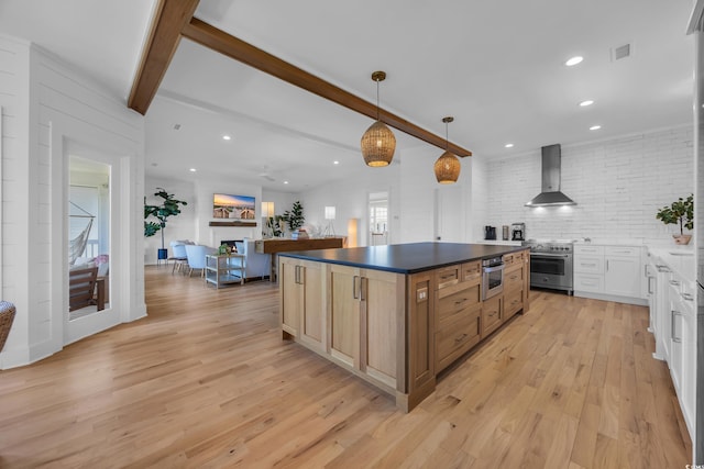 573 S Dunes Dr, Pawleys Island, SC 29585 - kitchen with wall chimney exhaust hood, high end stainless steel range oven, beam ceiling, light wood-style floors, and dark countertops