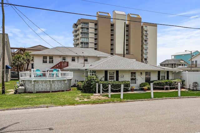 2006 S Ocean Blvd, North Myrtle Beach, SC 29582 - view of front facade featuring a front yard, an outdoor pool, and roof with shingles