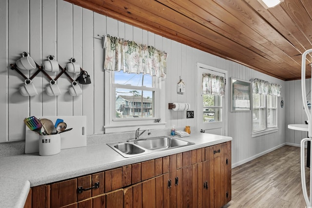 2006 S Ocean Blvd, North Myrtle Beach, SC 29582 - kitchen with wood ceiling, a sink, light countertops, light wood-style floors, and brown cabinets