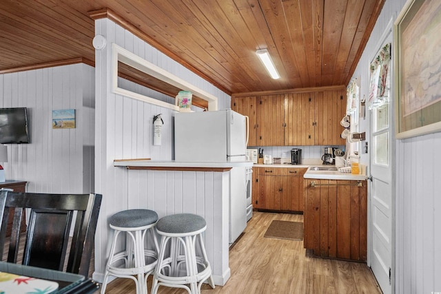 2006 S Ocean Blvd, North Myrtle Beach, SC 29582 - kitchen with wooden ceiling, brown cabinets, light countertops, light wood-type flooring, and wooden walls