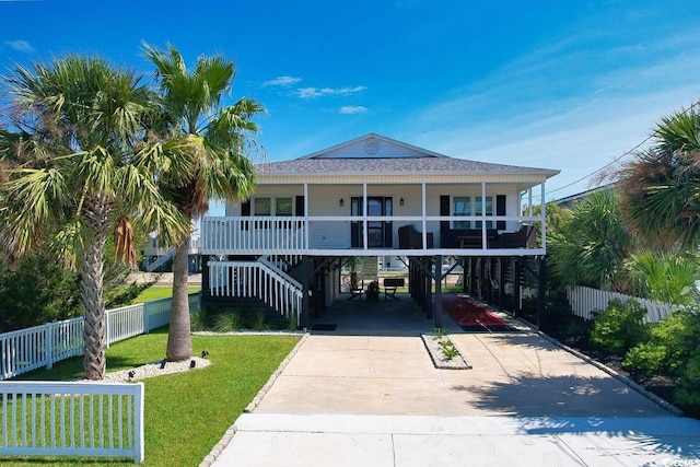 312 35th Ave N, North Myrtle Beach, SC 29582 - coastal inspired home featuring a carport, driveway, a porch, a shingled roof, and stairs