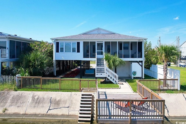 312 35th Ave N, North Myrtle Beach, SC 29582 - back of property with stairs, a sunroom, and roof with shingles