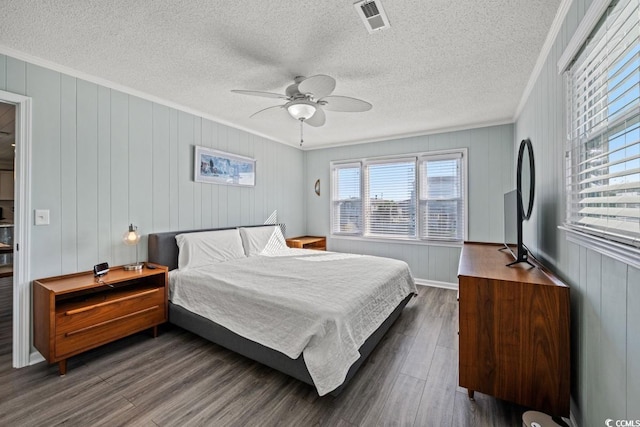 312 35th Ave N, North Myrtle Beach, SC 29582 - bedroom with crown molding, dark wood finished floors, a textured ceiling, a ceiling fan, and wood walls
