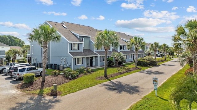 1890 Colony Dr Unit 17L, Surfside Beach, SC 29575 - view of front of home featuring a residential view, roof with shingles, stucco siding, central air condition unit, and uncovered parking