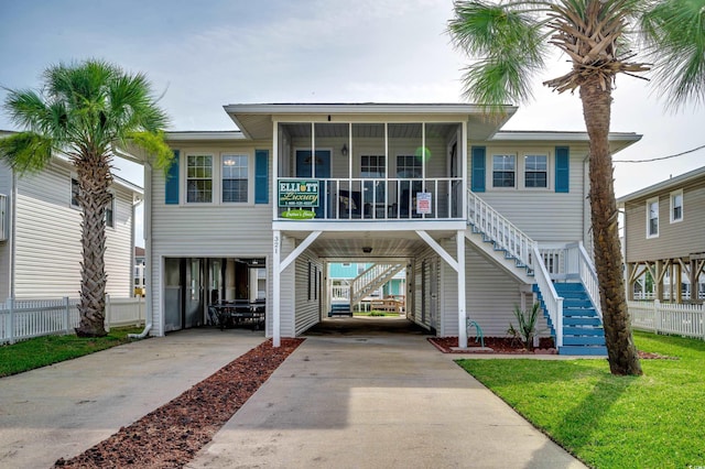 321 53rd Ave N, North Myrtle Beach, SC 29582 - view of front of home featuring a carport, stairway, concrete driveway, and a sunroom