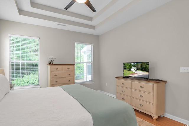 161 Patriot Ln, Pawleys Island, SC 29585 - bedroom with light wood-type flooring, a raised ceiling, and ceiling fan