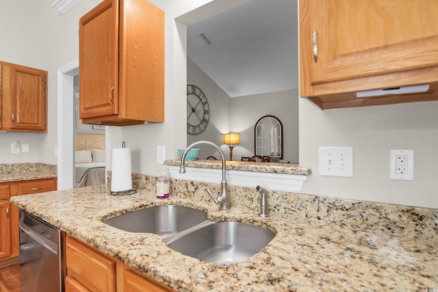 161 Patriot Ln, Pawleys Island, SC 29585 - kitchen featuring dishwasher, light stone countertops, and brown cabinets