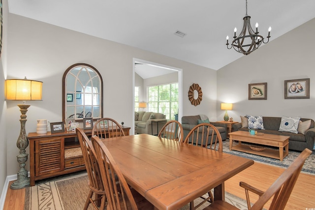 161 Patriot Ln, Pawleys Island, SC 29585 - dining space featuring vaulted ceiling, light wood-style floors, and a chandelier