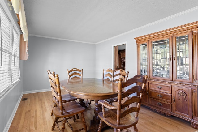 308 Old Stage Rd, Mullins, SC 29574 - dining room featuring light wood-style flooring, baseboards, crown molding, and a textured ceiling