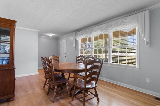 308 Old Stage Rd, Mullins, SC 29574 - dining room featuring light wood-style flooring, crown molding, a textured ceiling, and baseboards