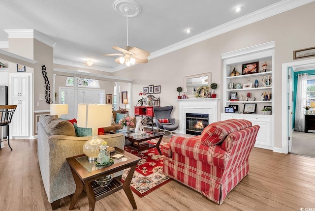 6434 Longwood Dr, Murrells Inlet, SC 29576 - living area featuring crown molding, light wood-type flooring, a glass covered fireplace, a ceiling fan, and baseboards