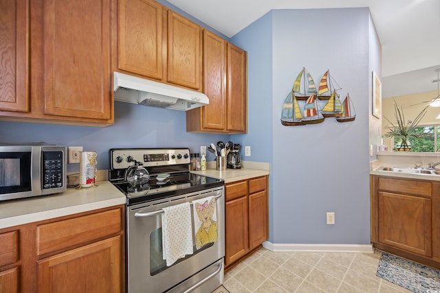 265 Connemara Dr Unit D, Myrtle Beach, SC 29579 - kitchen with stainless steel appliances, under cabinet range hood, baseboards, light countertops, and a sink