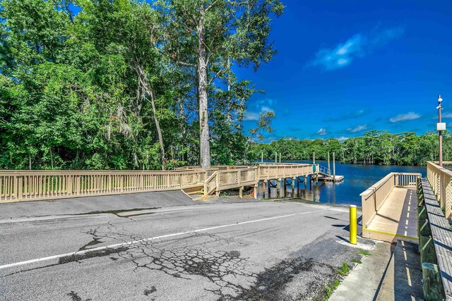 904 Moultrie Cir, Myrtle Beach, SC 29588 - dock featuring a water view, a boat ramp, and view of wooded area