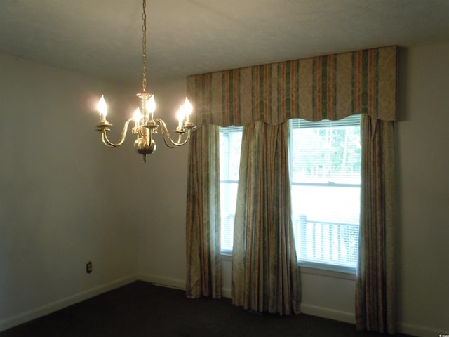8202 Joe Brown Hwy S, Clarendon, NC 28432 - empty room featuring a chandelier, plenty of natural light, baseboards, and dark colored carpet