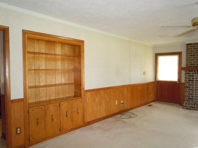 8202 Joe Brown Hwy S, Clarendon, NC 28432 - spare room featuring crown molding, wood walls, a wainscoted wall, ceiling fan, and carpet flooring