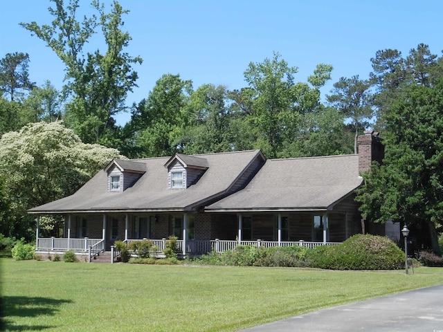 8202 Joe Brown Hwy S, Clarendon, NC 28432 - view of front of house with covered porch, a front lawn, a chimney, and a shingled roof