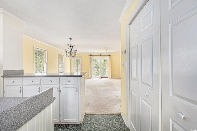 910 N Dogwood Dr, Surfside Beach, SC 29575 - hallway featuring crown molding, a chandelier, dark colored carpet, baseboards, and a textured ceiling