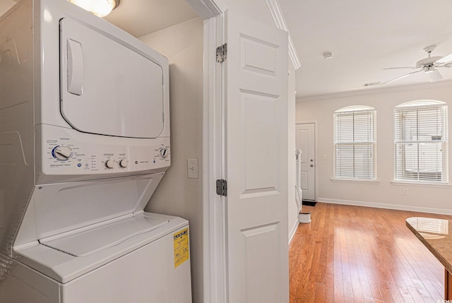 750 Howard Ave Unit E, Myrtle Beach, SC 29577 - washroom with stacked washing machine and dryer, a ceiling fan, light wood-style floors, crown molding, and baseboards