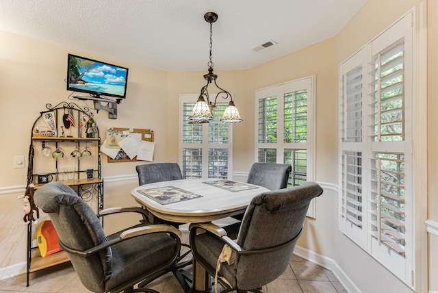 24 Gate 7, Carolina Shores, NC 28467 - dining area featuring light tile patterned flooring, a chandelier, and a textured ceiling