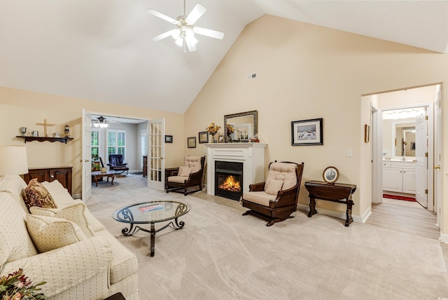 24 Gate 7, Carolina Shores, NC 28467 - living room featuring ceiling fan, french doors, high vaulted ceiling, light carpet, and a glass covered fireplace