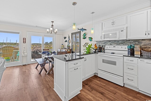 4534 Landing Rd, Little River, SC 29566 - kitchen featuring white appliances, a peninsula, dark countertops, a chandelier, and dark wood-style flooring