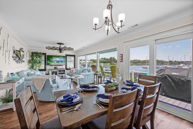 4534 Landing Rd, Little River, SC 29566 - dining space with a chandelier, crown molding, light wood finished floors, and a water view