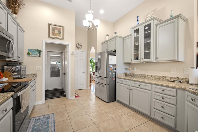 357 Southern Breezes Cir, Murrells Inlet, SC 29576 - kitchen with stainless steel appliances, arched walkways, glass insert cabinets, gray cabinets, and a high ceiling