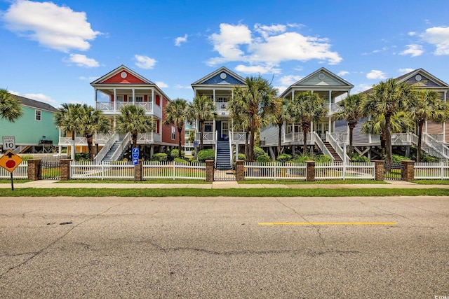 22 Ocean Blvd N, Surfside Beach, SC 29575 - view of front of home featuring stairs, a porch, a balcony, and a fenced front yard