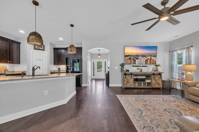 321 Sanctuary Ct, Myrtle Beach, SC 29588 - kitchen featuring a ceiling fan, arched walkways, light stone countertops, dark brown cabinetry, and recessed lighting