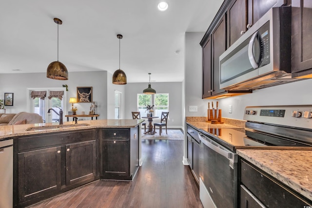 321 Sanctuary Ct, Myrtle Beach, SC 29588 - kitchen featuring appliances with stainless steel finishes, dark brown cabinets, light stone counters, dark wood-type flooring, and decorative light fixtures