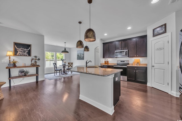 321 Sanctuary Ct, Myrtle Beach, SC 29588 - kitchen featuring appliances with stainless steel finishes, light stone counters, dark wood-style floors, recessed lighting, and arched walkways